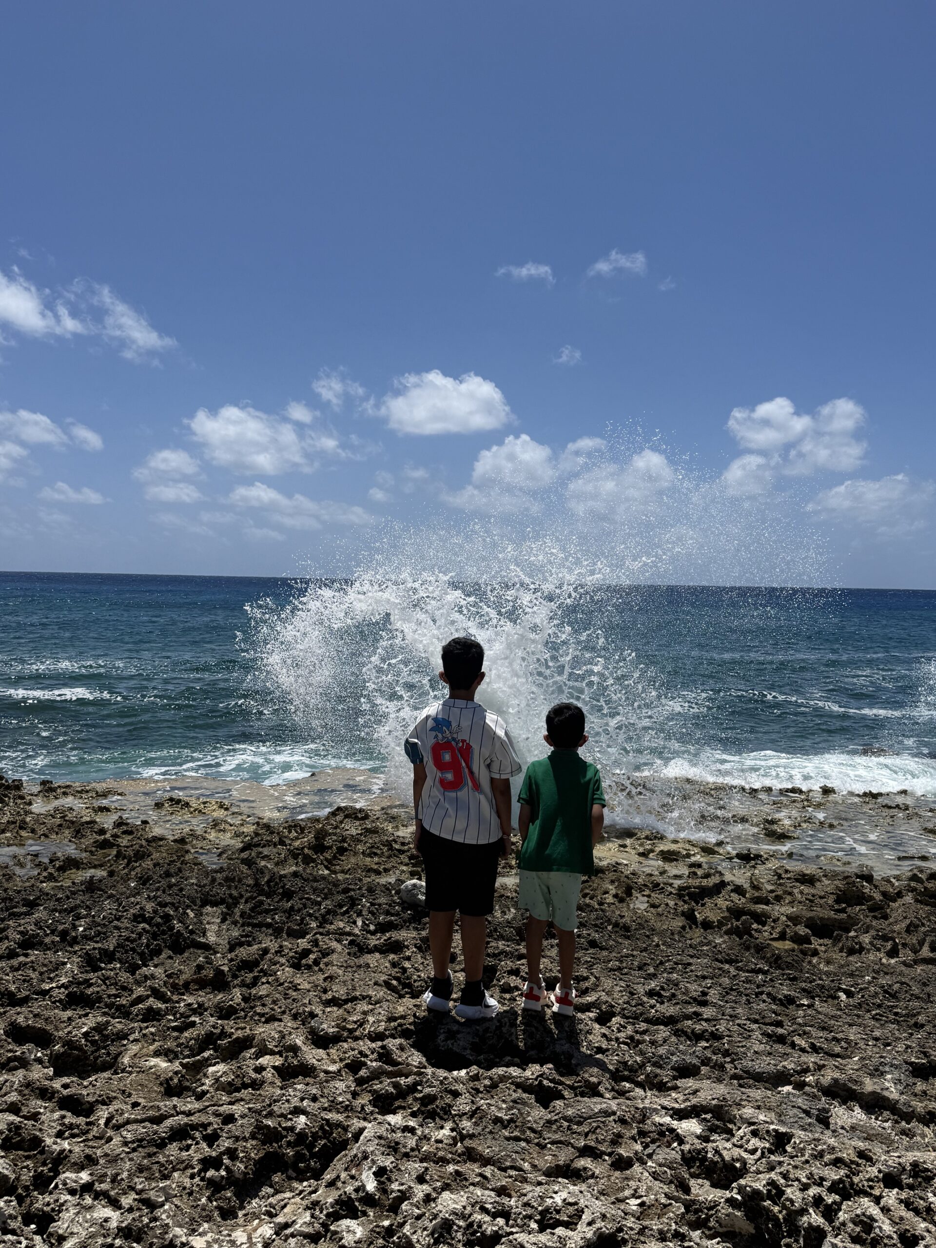 Kids watching the East End blowholes erupt in Grand Cayman